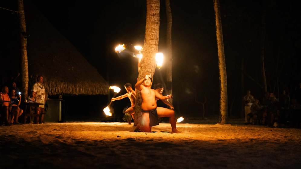 Enjoy a sunset feast on a private island near Bora Bora, followed by a heart-pounding fire dance.
